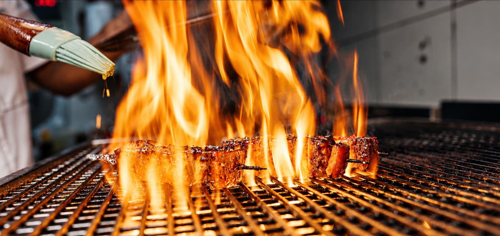 Flames leaping from a charcoal grill in an open kitchen