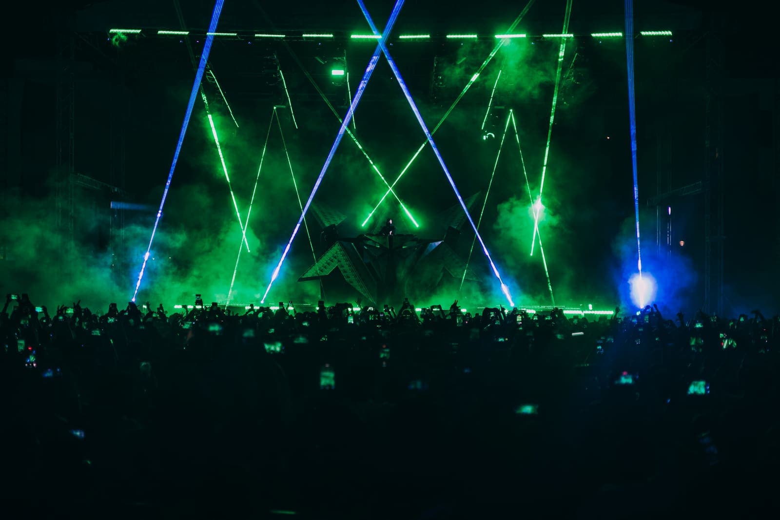 Green lasers over a packed club dance floor