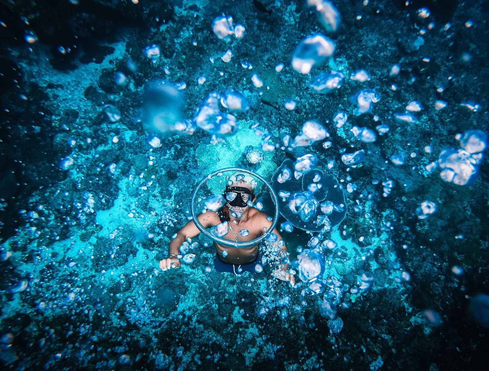Diver surrounded by bubbles in deep blue water
